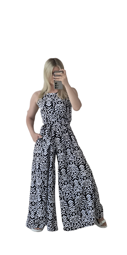 Woman wearing a black and white patterned strapless jumpsuit on a white background