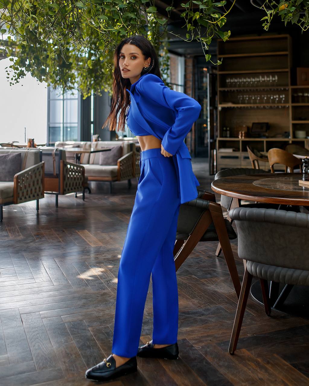 Woman in a blue outfit standing in a modern restaurant setting