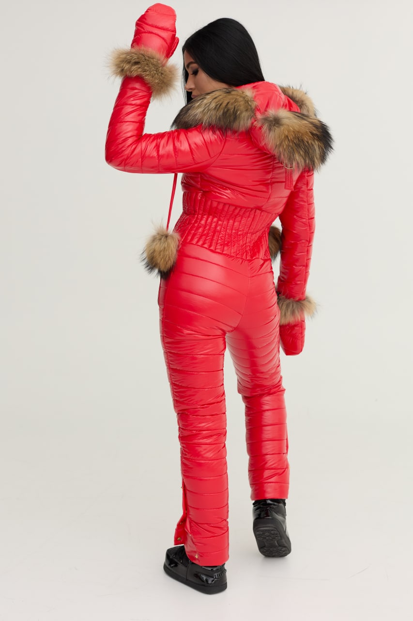 Person wearing a red snowsuit with fur trim on a white background