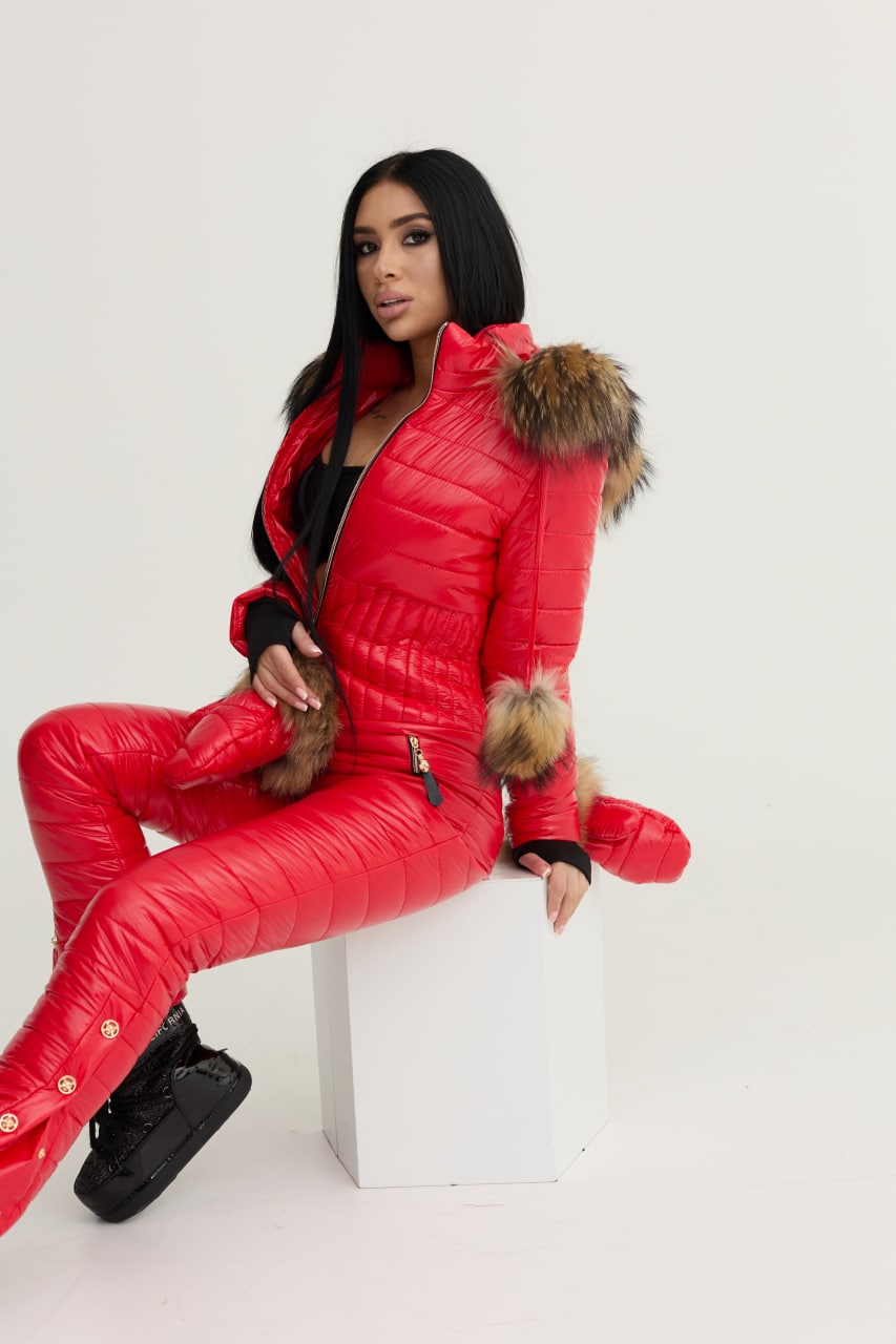 Person wearing a red puffer suit with fur trim on a white background