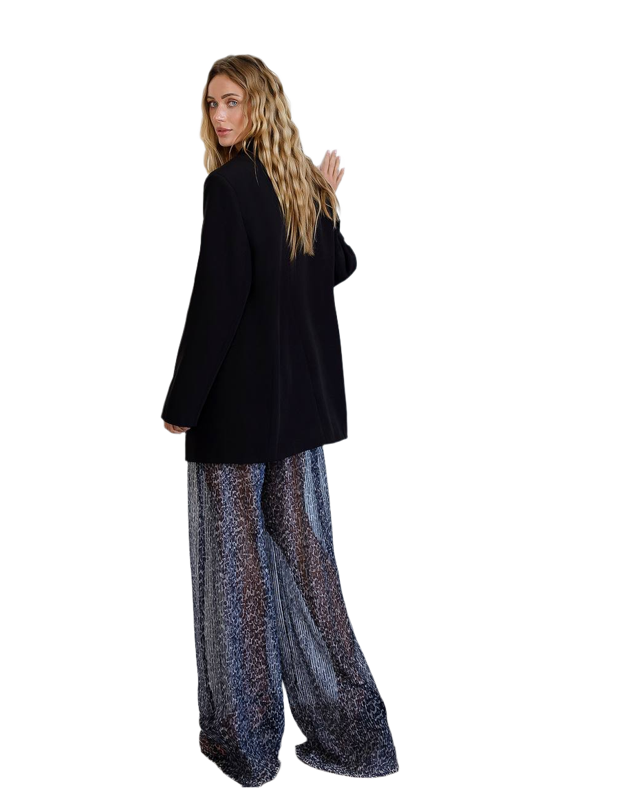 Person wearing a black coat and patterned pants on a white background