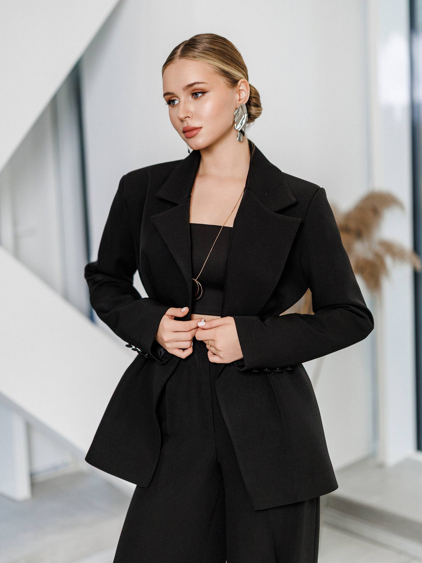 Woman wearing a black suit in an indoor setting