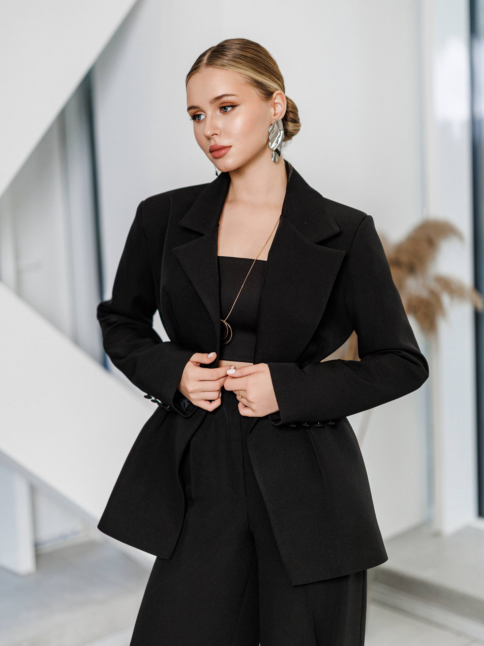 Woman wearing a black suit in an indoor setting