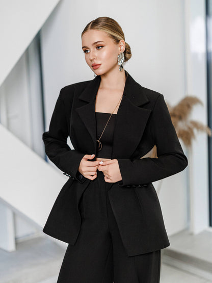 Woman wearing a black suit in an indoor setting