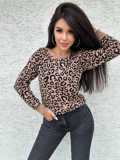 Woman wearing a leopard print sweater against a light gray wall