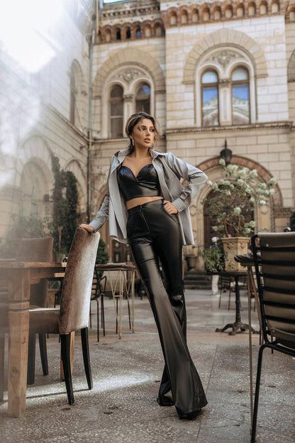 Woman in a stylish outfit standing in an outdoor setting with architectural background