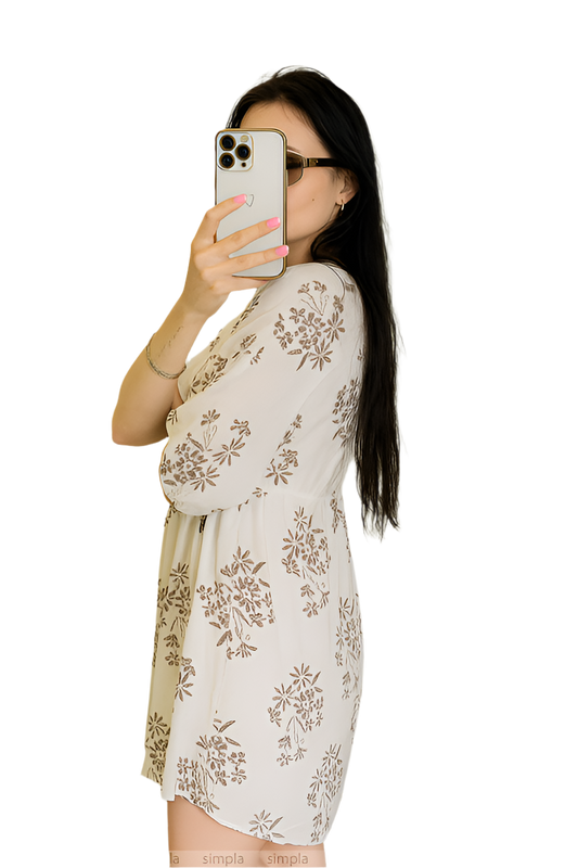 Woman taking a selfie wearing a floral dress on a white background