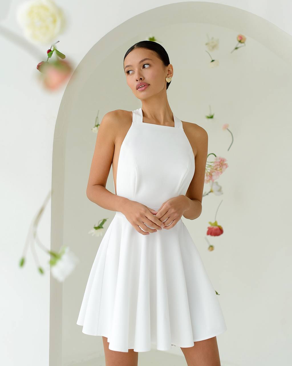 Woman wearing a white dress against a floral background