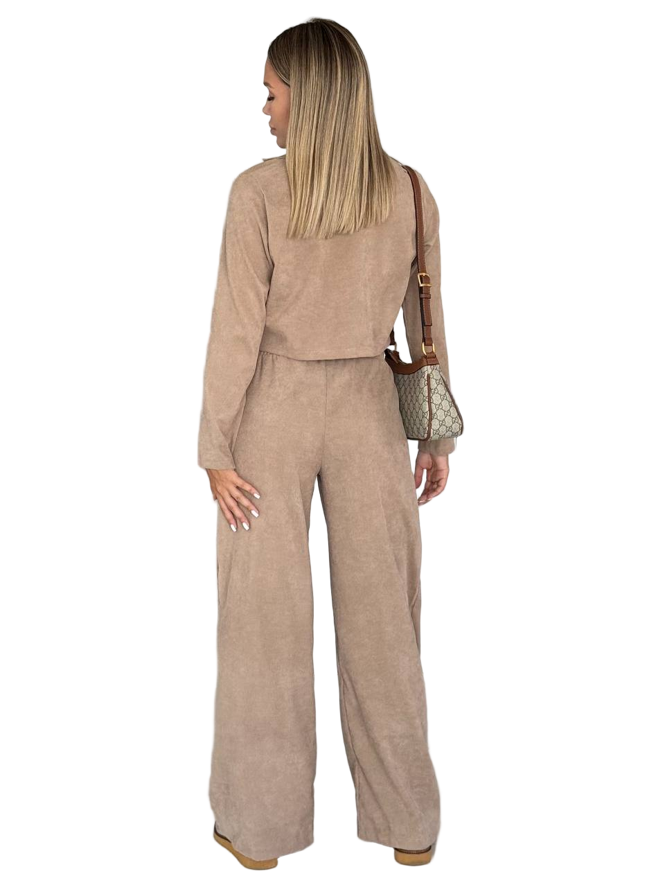 Woman wearing a beige outfit with wide-leg pants and a matching jacket, carrying a brown handbag on a white background.