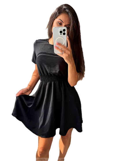 Woman wearing a black dress holding a phone with a white background