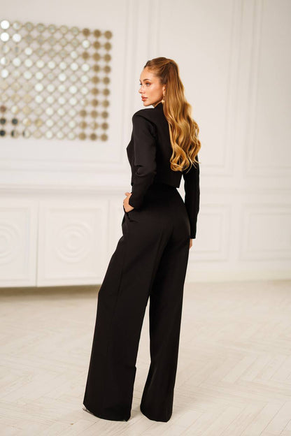 Woman wearing a black outfit in a minimalistic room.