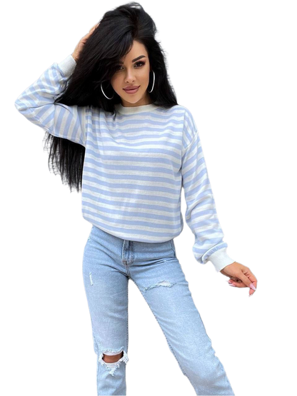 Woman wearing a blue and white striped sweater and light blue jeans on a white background