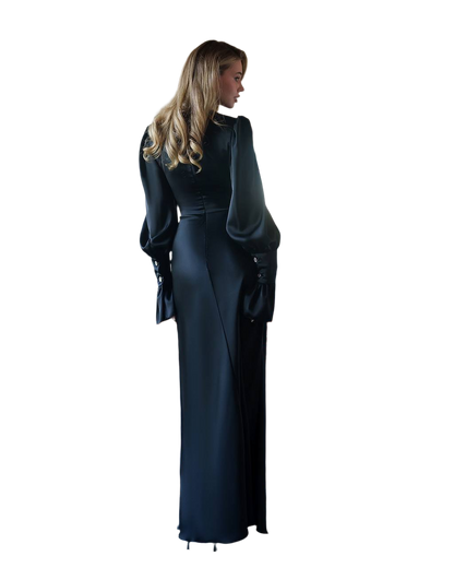 Woman wearing a long black dress with a fitted bodice and flowing skirt on a white background