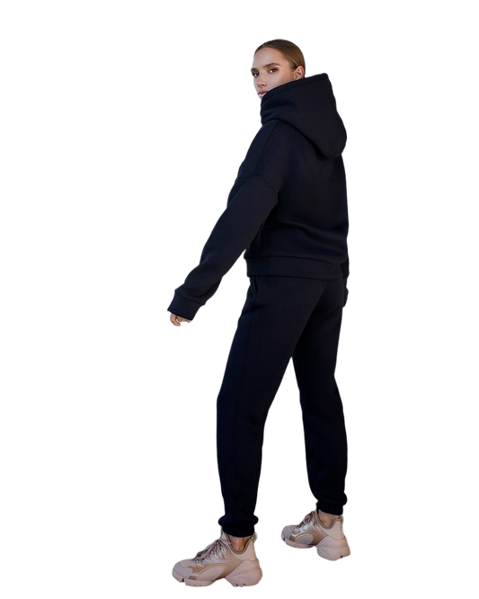 Person wearing a black hoodie and pants on a white background