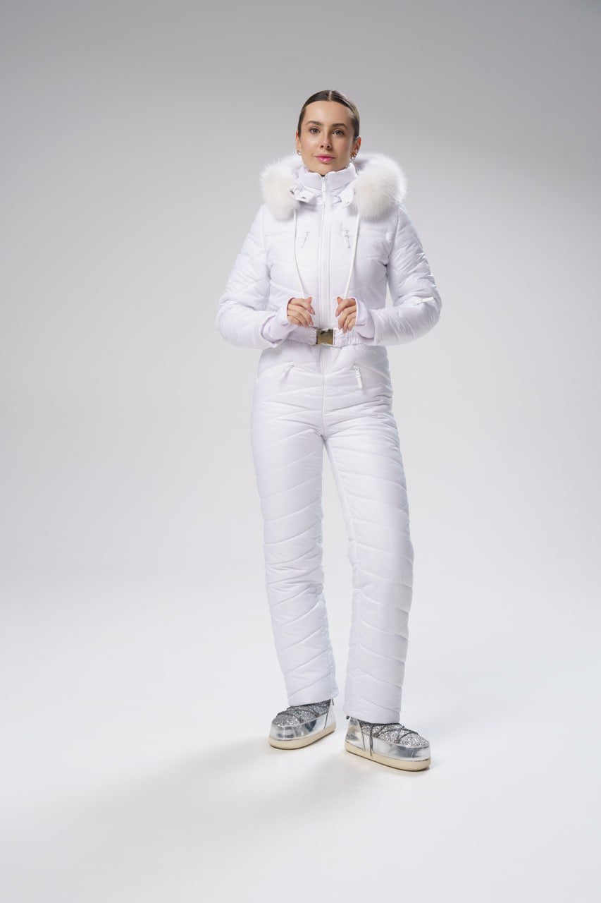 Person wearing a white puffer suit with fur trim on a gray background