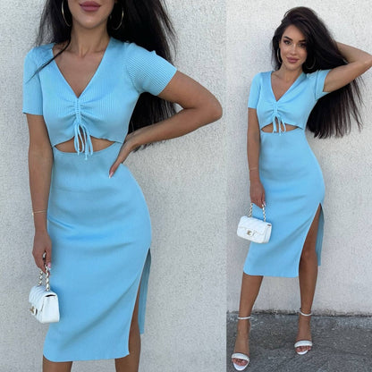Woman wearing a light blue dress with cut-out design and side slit, posing against a plain background.