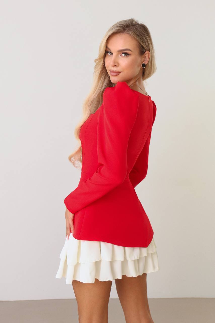 Woman wearing a red top and white skirt against a plain background