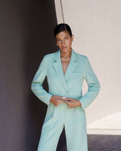 Woman wearing a light blue suit against a neutral background