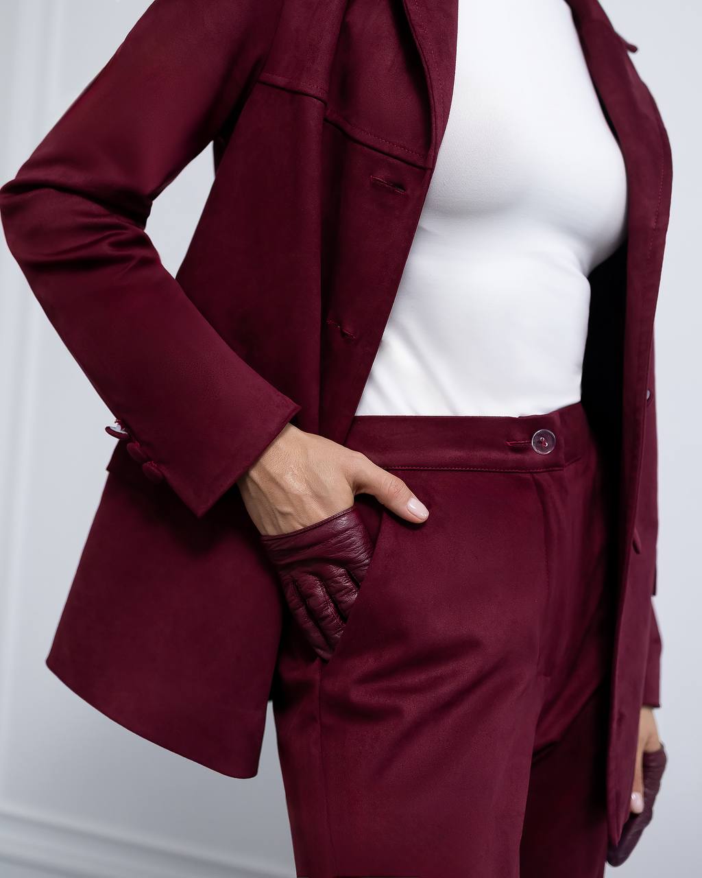 Maroon suit with white top on a plain background