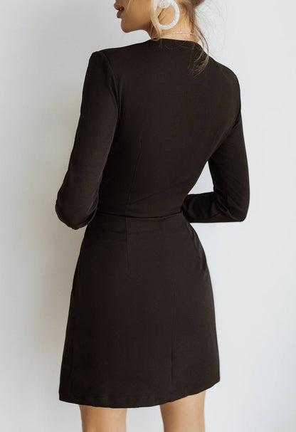 Black long-sleeve dress worn by a person against a white background