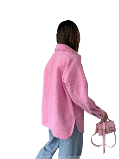 Person wearing a pink coat holding a matching handbag on a white background