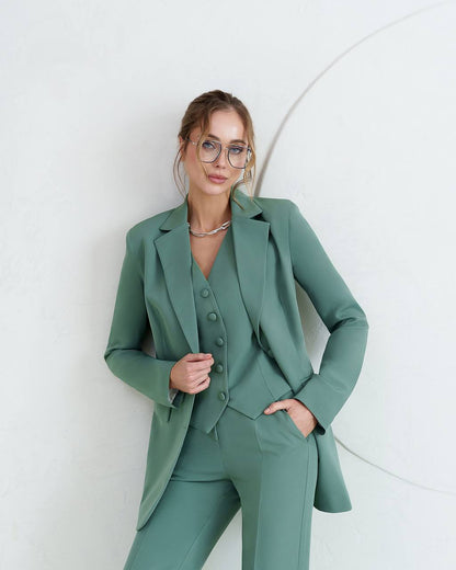 Woman wearing a green suit against a white background