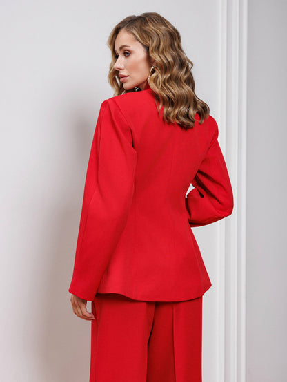 Woman wearing a red suit against a plain background