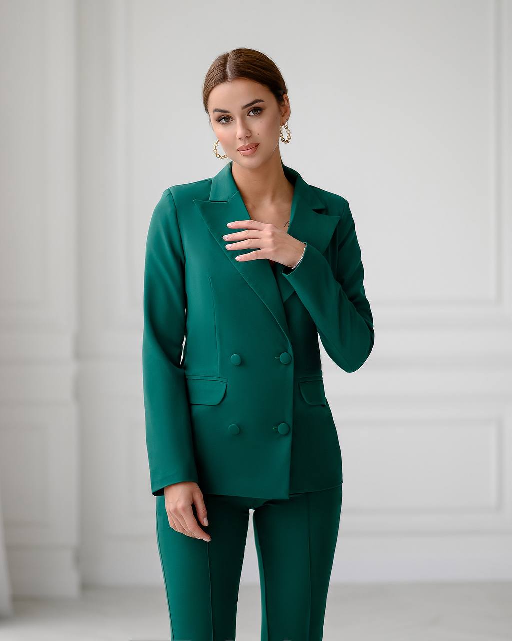 Woman wearing a green suit against a white background