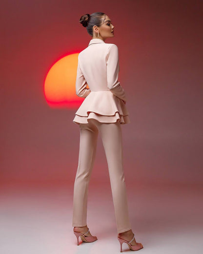 Woman in a beige suit standing with a sunset in the background