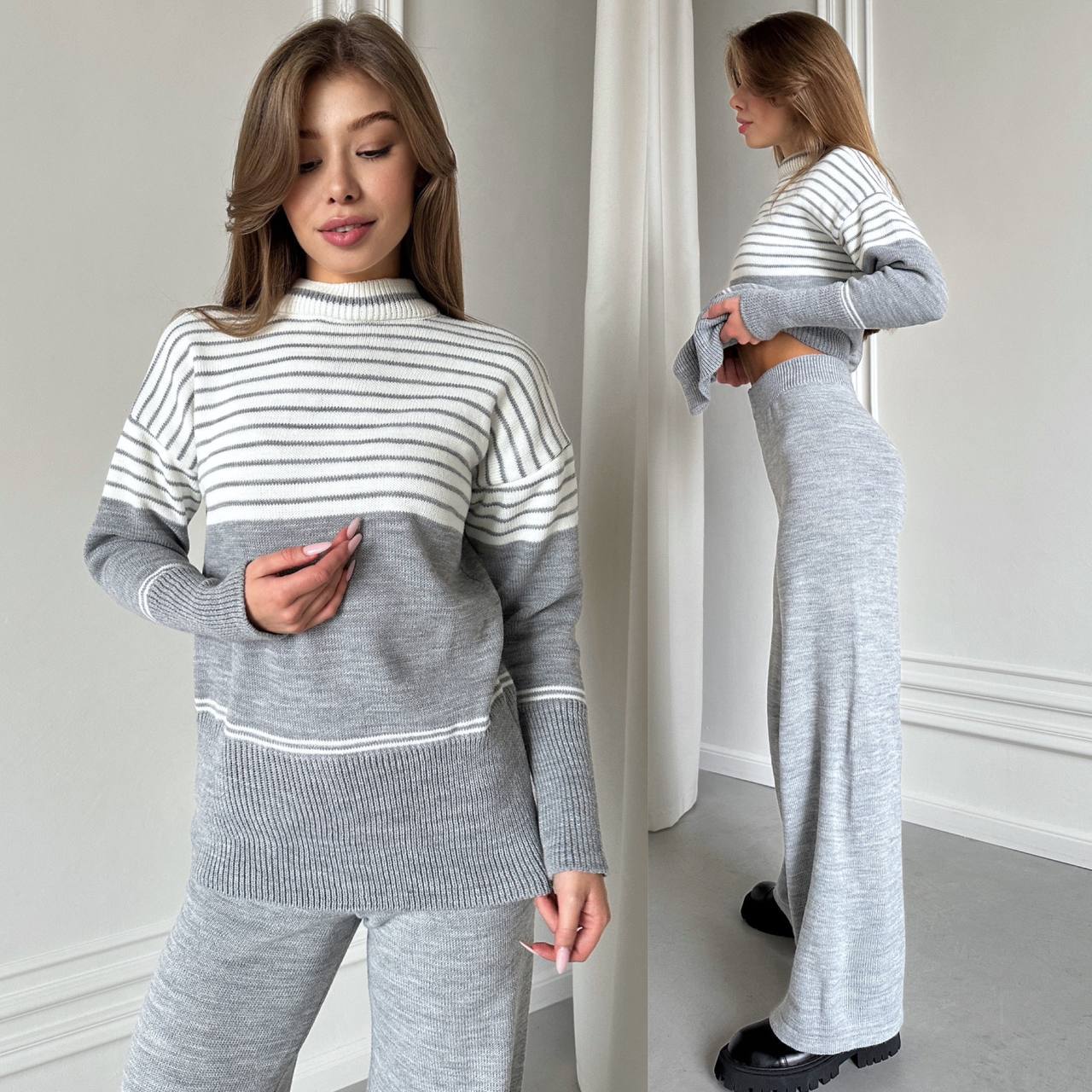 Woman wearing a gray and white striped sweater and pants set in a minimalistic room.