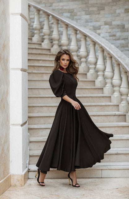 Woman in a black dress standing on a marble staircase