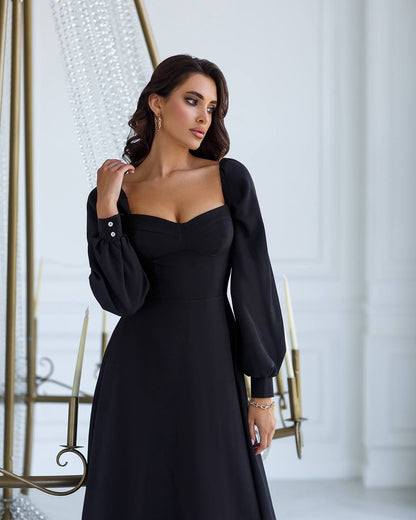 Woman wearing a black dress in an elegant indoor setting