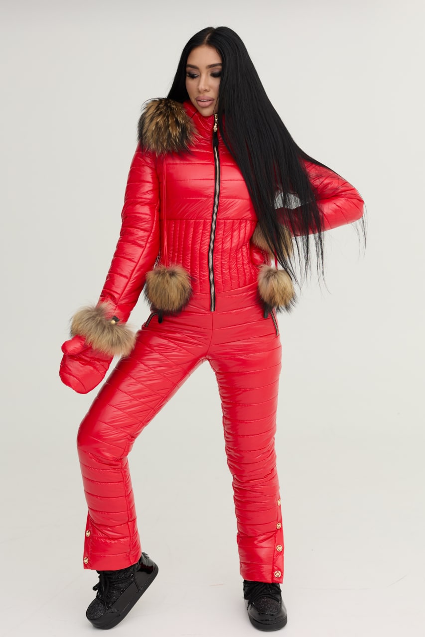 Person wearing a red puffer jumpsuit with fur trim on a white background