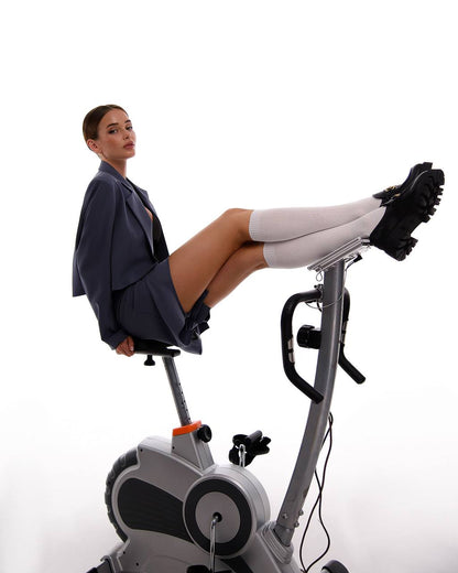 Woman exercising on a stationary bike against a white background
