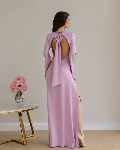 Woman wearing a pink evening gown with a table and flowers in the background