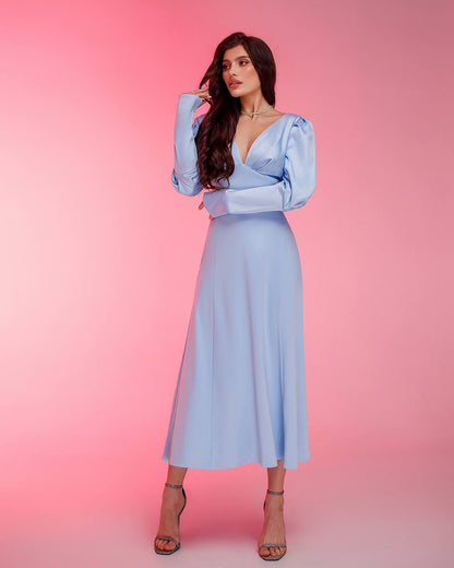 Woman wearing a light blue dress with a pink gradient background
