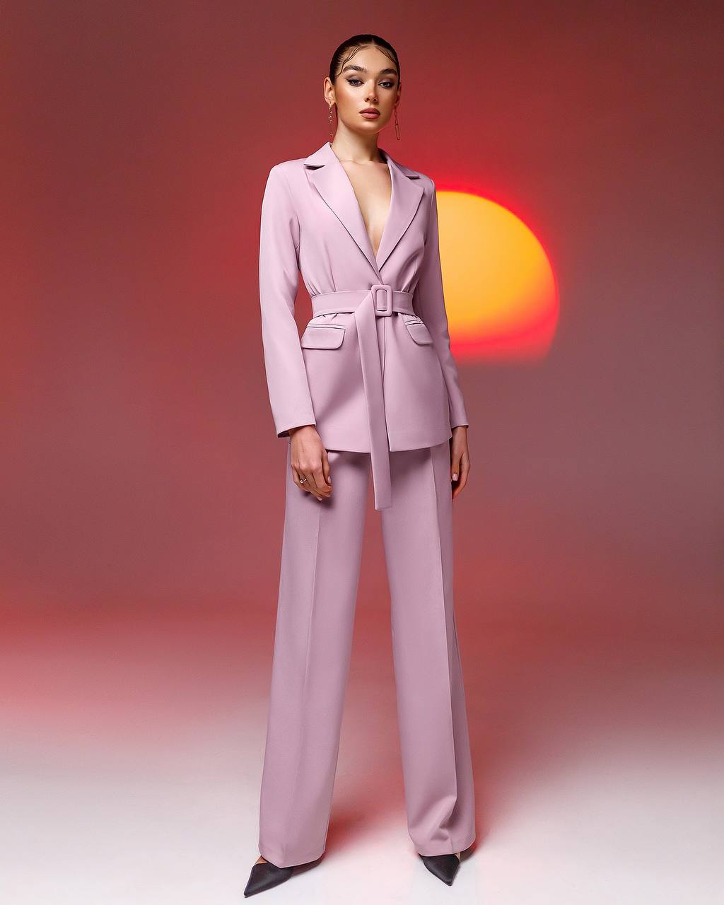 Woman wearing a light purple suit with a sunset in the background