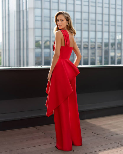 Woman in a red dress standing on a rooftop with cityscape background