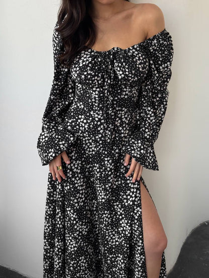 Black and white floral off-shoulder dress with long sleeves and a slit on a plain background