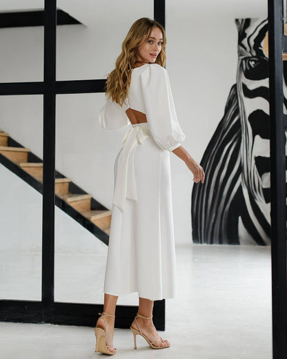 Woman in a white outfit standing in a modern interior setting with a zebra painting.