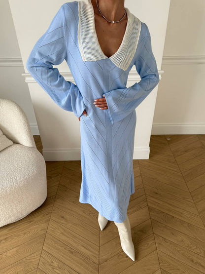 Person wearing a blue dress with a white collar in an indoor setting