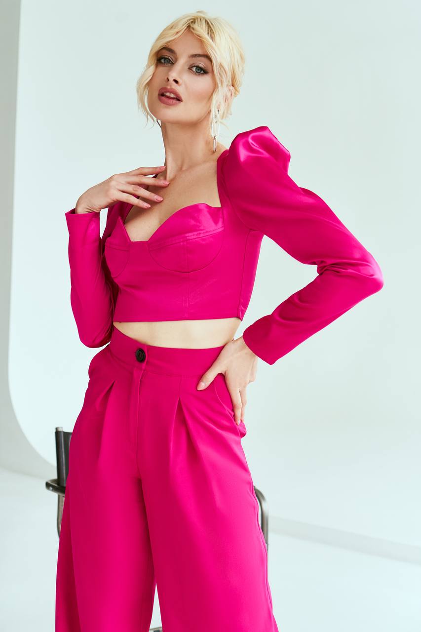 Woman wearing a bright pink outfit with a white background