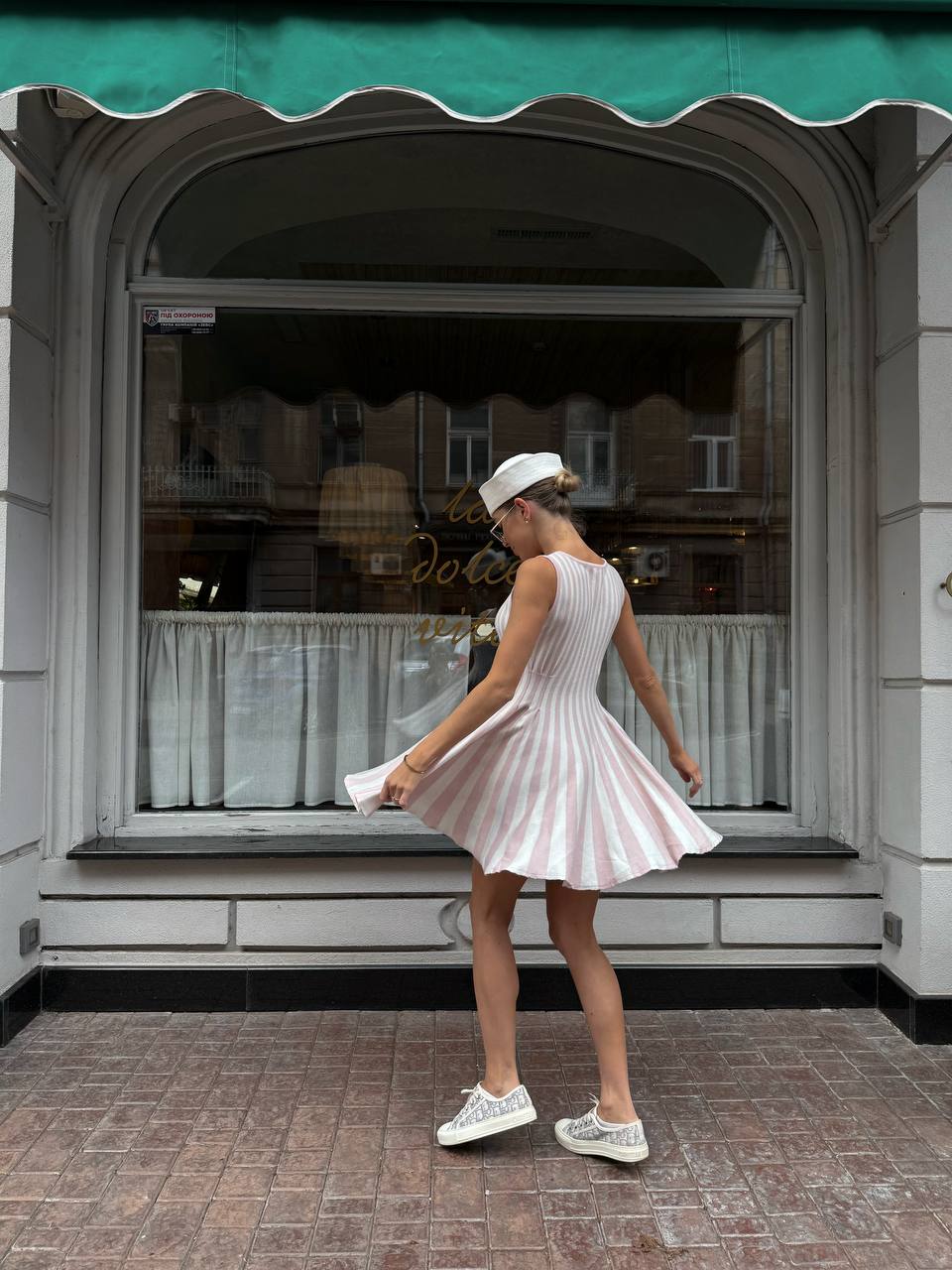 Woman in a pink dress standing in front of a store window