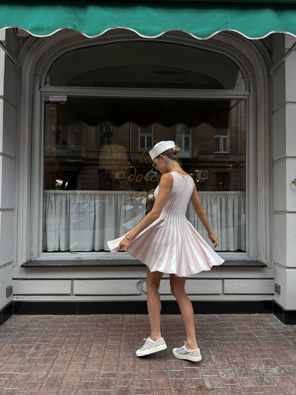 Woman in a pink dress standing in front of a store window