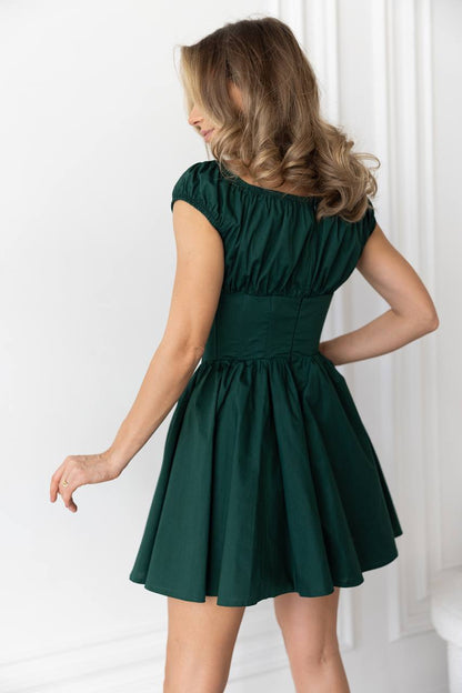 Woman wearing a green dress against a white background