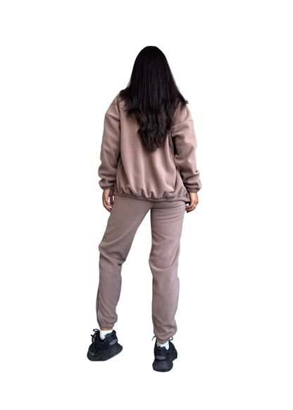 Person wearing a beige tracksuit on a white background