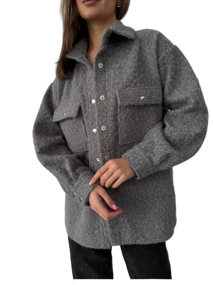 Person wearing a gray coat with button details on a white background