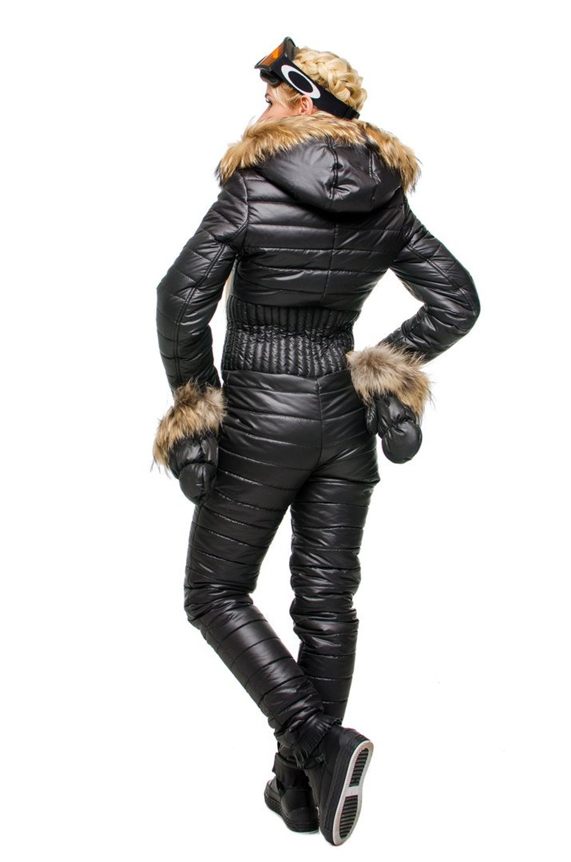 Person wearing a black winter coat with fur trim on a white background