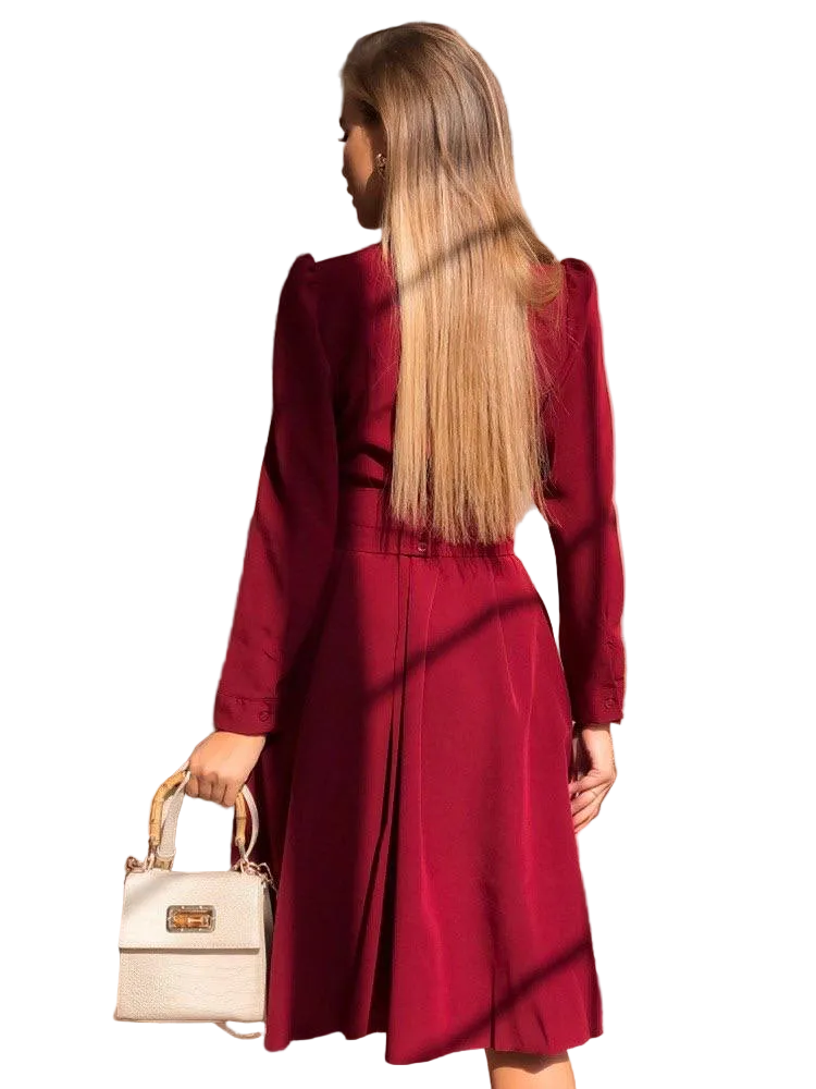 Woman wearing a red coat holding a beige handbag on a white background