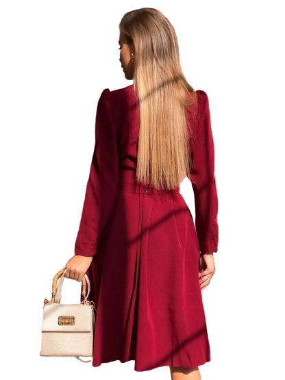 Woman wearing a red coat holding a beige handbag on a white background